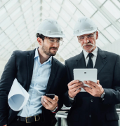 two-successful-entrepreneur-helmet-with-project-laptop-new-buildings-stay-near-glass-roof_496169-971 1