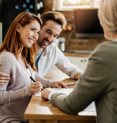 young-happy-woman-her-husband-signing-agreement-with-insurance-agent-during-meeting-min 1